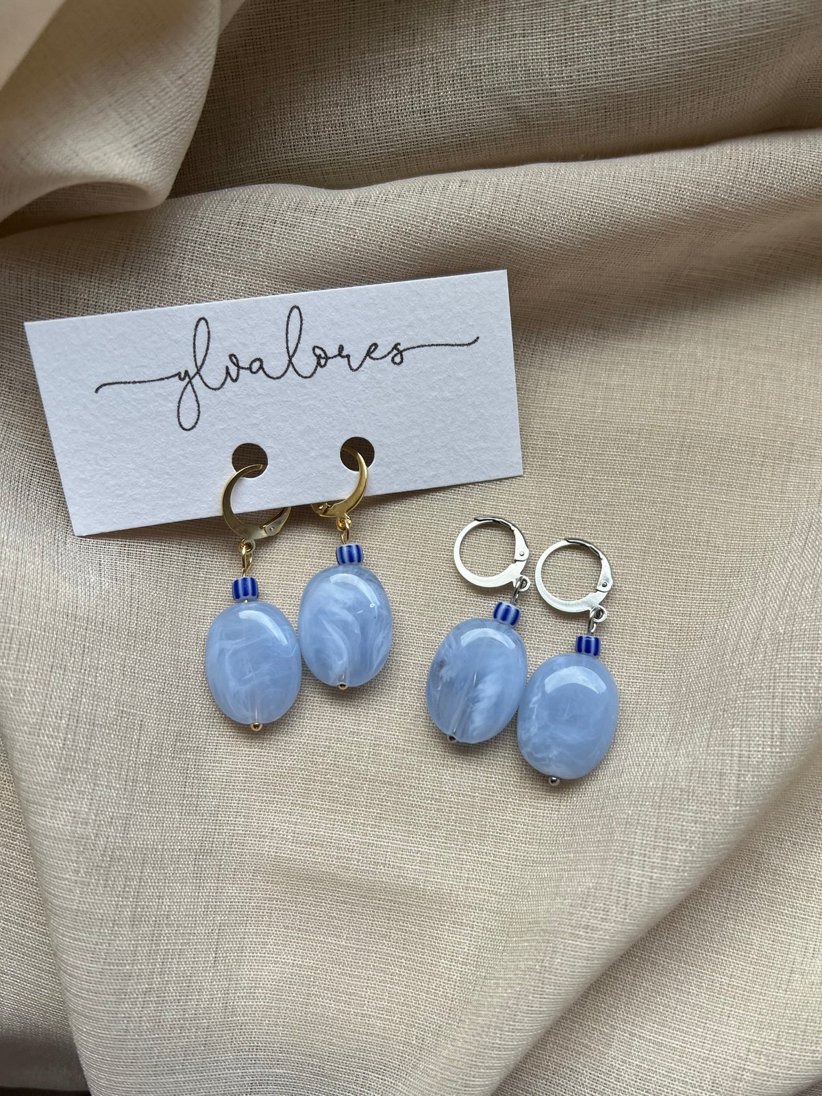 Handgefertigte Ohrringe aus transparent blauem Acryl, Edelstahl und einer gereiften Perle. Eleganter Statement-Schmuck mit sanfter Farbwirkung.