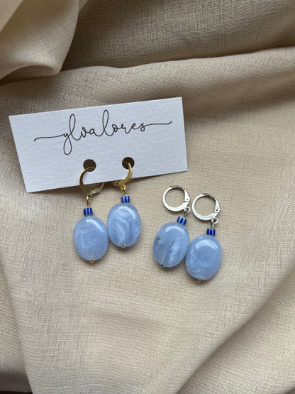 Handgefertigte Ohrringe aus transparent blauem Acryl, Edelstahl und einer gereiften Perle. Eleganter Statement-Schmuck mit sanfter Farbwirkung.