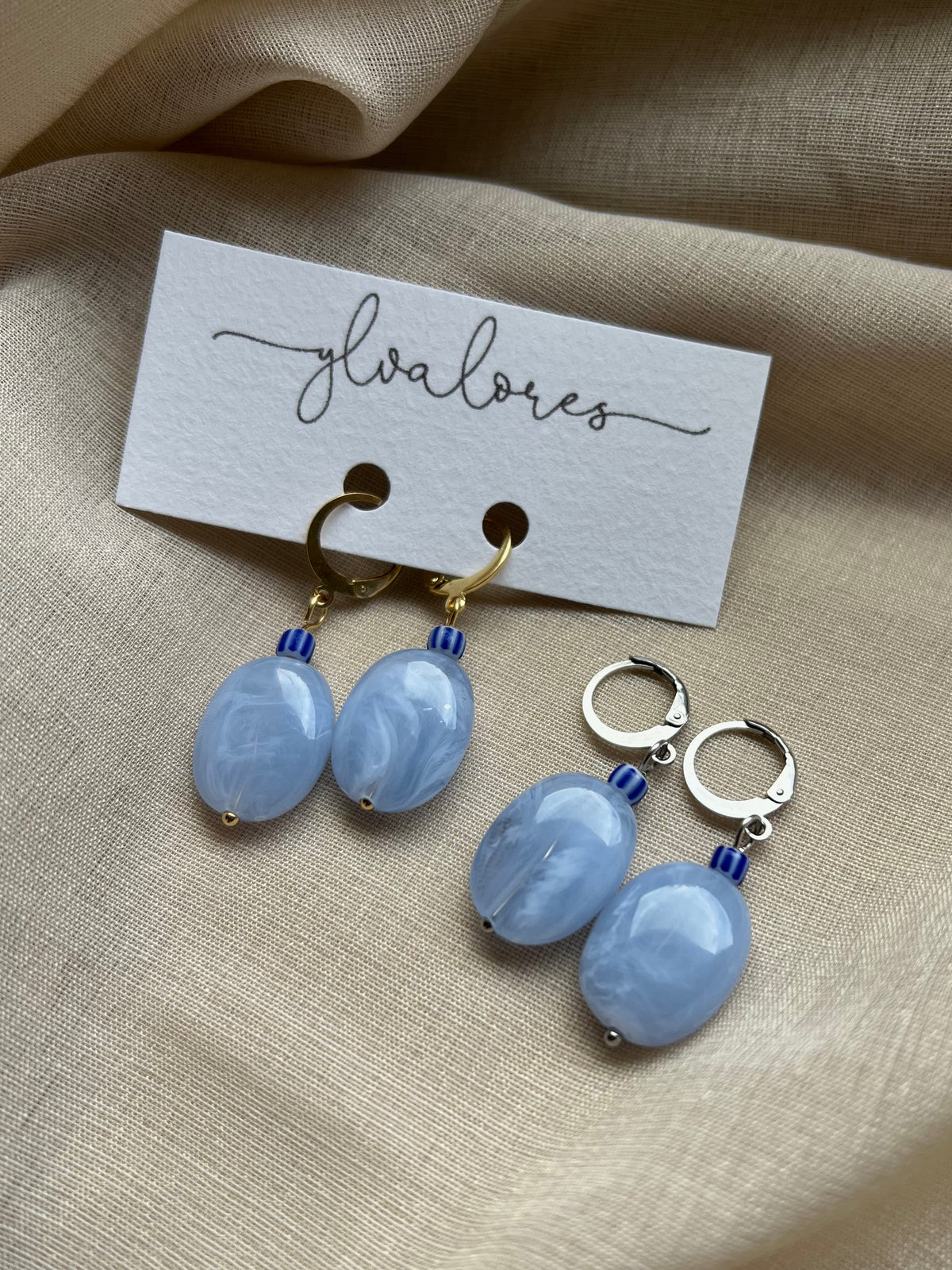 Moderne Ohrringe aus blauem Acryl kombiniert mit hochwertigem Edelstahl und einer besonderen Perle. Auffälliges Design in einer zarten, frischen Farbnuance.